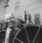 Bryce's Mountain Resort, view from the ground of two men standing on the water wheel. Basye, Va. by William Garber