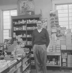 Alternate view of shelving inside of a store or building with a man pictured in a different location. by William Garber