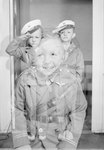 Two young boys in uniform, possibly boy scout uniforms, standing in salute. Similar image of a boy smiling also visible by William Garber
