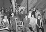 A large group of men posing in a garage, shop, or other manual work space by William Garber