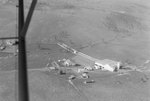 Close up view of a farm that is partially obstructed by a part of the plane by William Garber