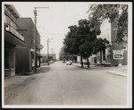 View from the middle of the street, with a movie theater and a number of other stores on either side. Probably Broadway, Va. by William Garber