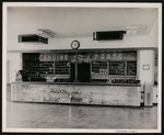 Inside of an automotive store; view of the main counter and cash register, with an advertisement for Ford auto parts by William Garber