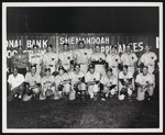 The Woodstock baseball team posing in front of a fence advertising for businesses in Woodstock, Va. by William Garber