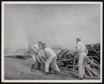 Four men working on the construction site of a large building by William Garber