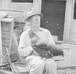 Man holding a chicken at the Mt. Jackson Mill. by William Garber