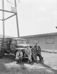 Four men posing in front of a company truck for the Grabole Company: Roofing and Spray Painting Contractors by William Garber