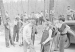 A larger group of CCC workers standing in a heavily wooded area by William Garber