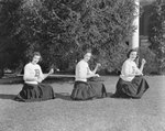 Broadway (High) School, three cheerleaders practicing a routine in the grass. by William Garber