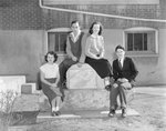 Broadway (High) School, four young men and women posing next to the school plaque. by William Garber