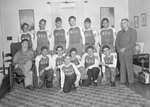 Team photo of the men's baseball team for the Timberville Hatchery, with the letters "GIs" on their uniforms. Photo taken inside of a home or office; one member is in a wheelchair by William Garber