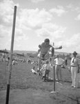 An athlete high jumping over a crossbar by William Garber