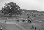 View of a large number of people on a sports field, taken from an upper story window and from a distance by William Garber