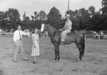 Timberville Horse Show, a man posing on a horse with a ribbon, and another man and woman standing nearby by William Garber
