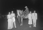 Timberville Horse Show, a man posing on a horse with a ribbon and trophy, and four other individuals standing close by by William Garber