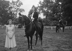 Broadway Horse Show, a woman posing on a horse and holding a ribbon, with another woman standing beside her by William Garber