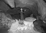 A young woman playing a violin inside of a large cavern by William Gaber