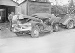 Front view of a severely damaged automobile that is hooked up to a tow truck, VA license plate 566-521 by William Garber