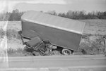 Alternate view of a tractor-trailer after a serious accident, mangled in a ditch off the side of the road. by William Garber