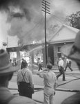 Men watching a building burn by William Garber